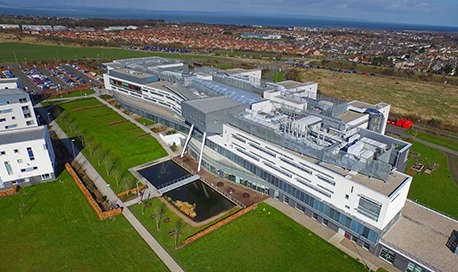 An aerial view of Queen Margaret University Campus with Edinburgh sprawling out beyond it