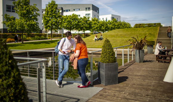 A couple of students chatting in the sun at Queen Margaret University, Edinburgh