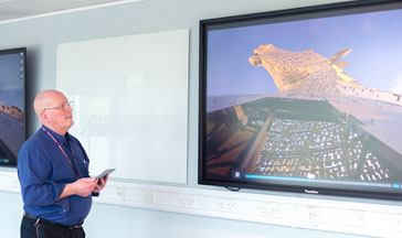 A 西瓜视频 staff member standing by 2 screens showing the Scottish Kelpies sculpture
